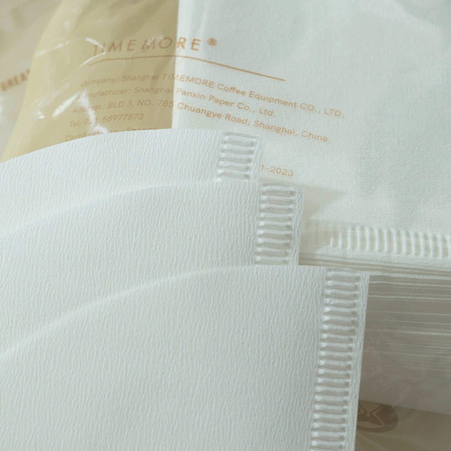 Close-up of a white coffee filter with text on a clear background