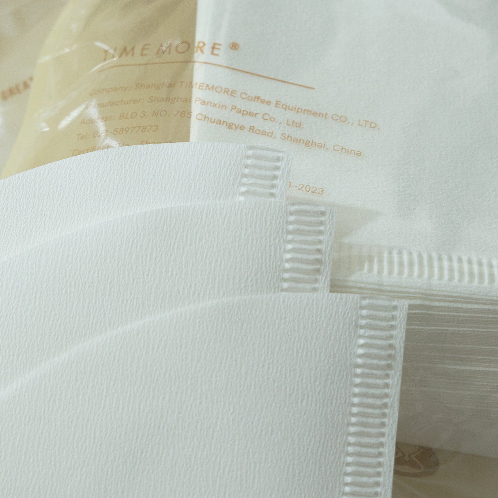 Close-up of a white coffee filter with text on a clear background