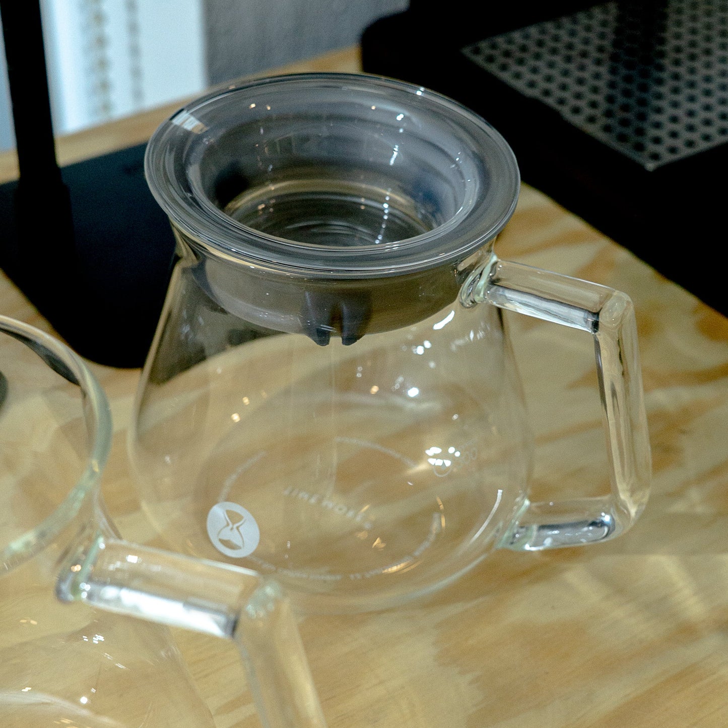 Clear glass carafe with handle on a wooden surface